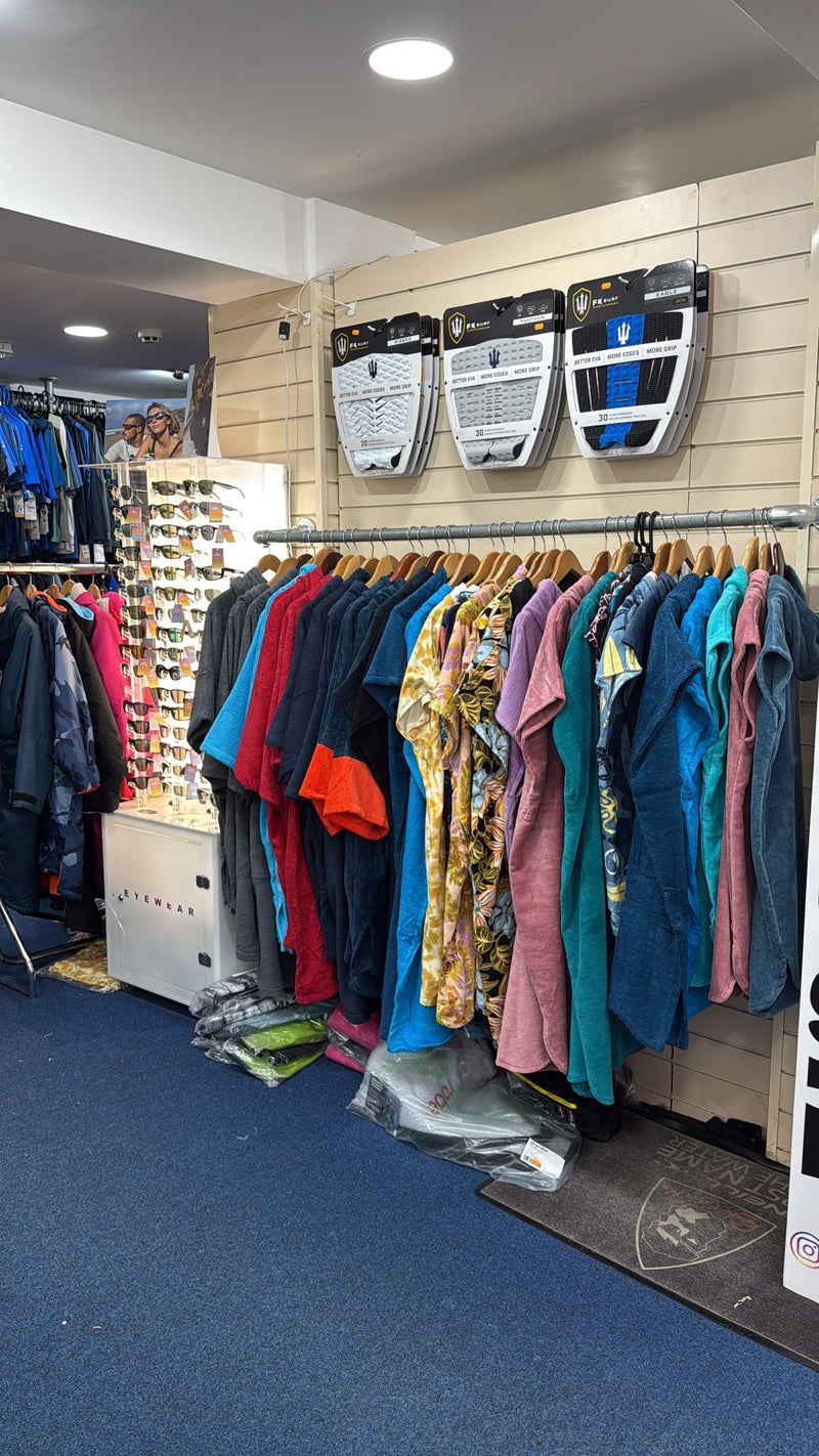 Selection of surfboard tail pads, changing robes and polarised sunglasses